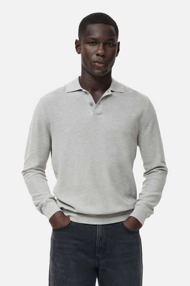 Grijze trui met ronde hals van MANGO, gedragen met een donkere jeans en handen in de zakken.