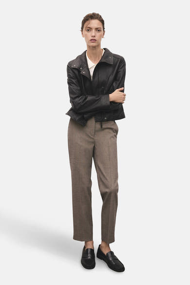 Pantalon brun chiné de MANGO, porté avec une veste en cuir noire et des chaussures mocassins noires.