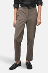 Pantalon marron à carreaux de MANGO, avec des plis nets et des mocassins noirs en cuir.
