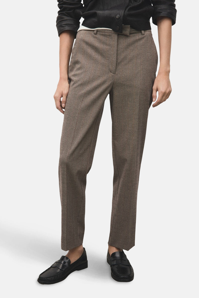 Pantalon marron à carreaux de MANGO, avec des plis nets et des mocassins noirs en cuir.
