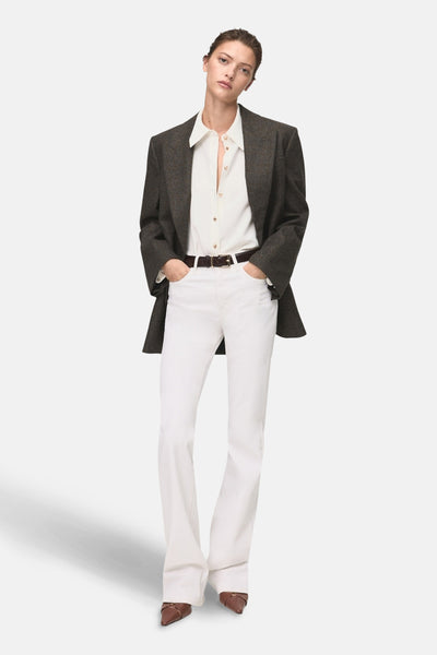 Ecru lange mouwen blouse van MANGO, gedragen met een geruite blazer en een witte jeans.