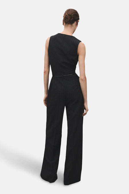 Blauwe gestreepte jumpsuit van MANGO, met een dunne zwarte riem, van achteren gezien.