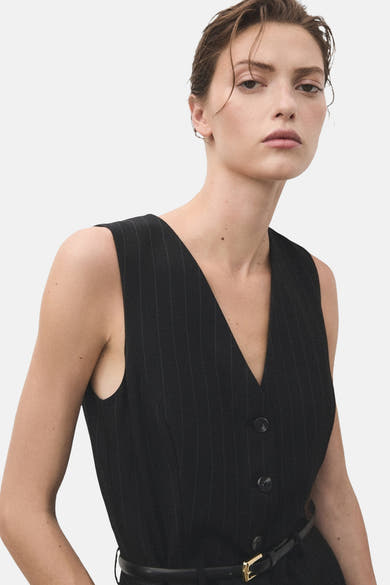 Blauwe gestreepte jumpsuit van MANGO, met een zwarte riem met gouden gesp.