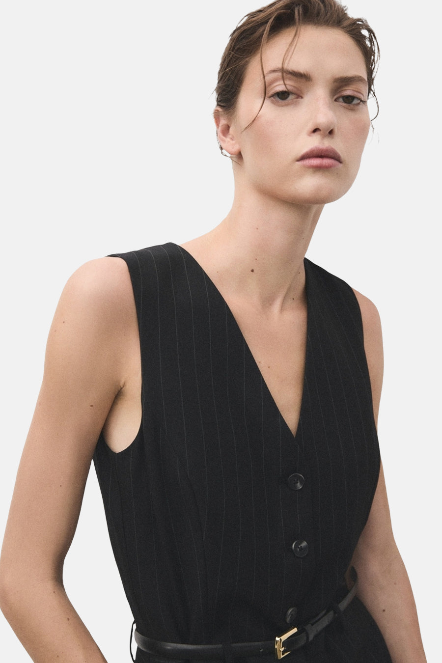 Blauwe gestreepte jumpsuit van MANGO, met een zwarte riem met gouden gesp.
