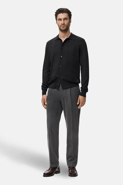 Grijze MANGO bodywarmer, gedragen met een bruine broek en schoenen, op een witte achtergrond.