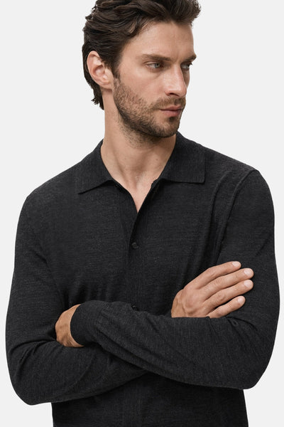 Grijze MANGO bodywarmer, met lange mouwen en polokraag, gedragen met gekruiste armen.