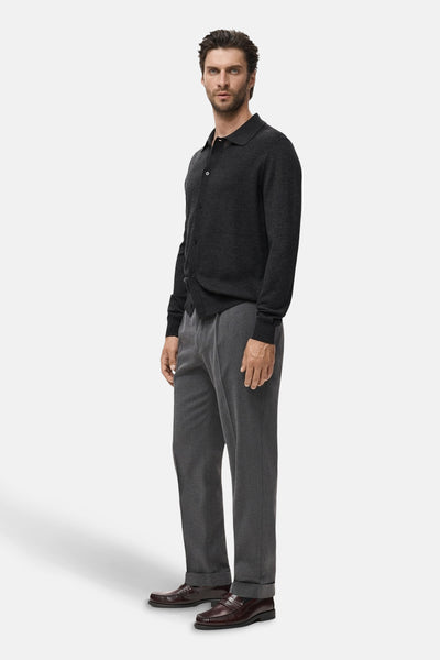 Grijze bodywarmer van MANGO, gedragen over een grijze broek en bruine leren schoenen.