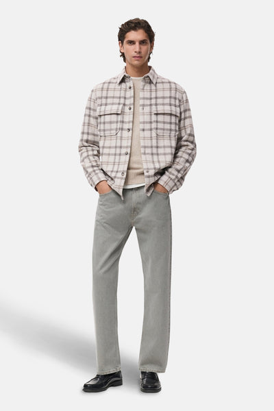 Veste courte multicolore de MANGO, à carreaux, portée avec un pull beige et un jean gris.
