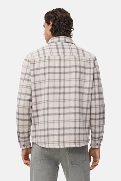 Veste courte à carreaux de MANGO, vue de dos, portée avec un pantalon vert sauge.