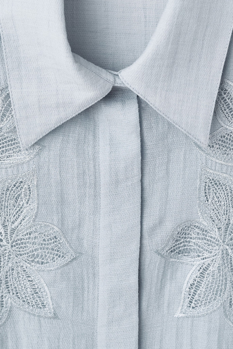 Chemise à manches longues bleue de MANGO, avec broderies florales et col classique.