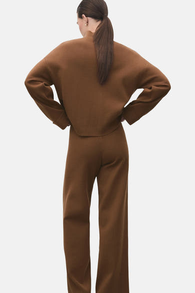 Pull à col roulé brun de MANGO, porté avec un pantalon coordonné, vue de dos.