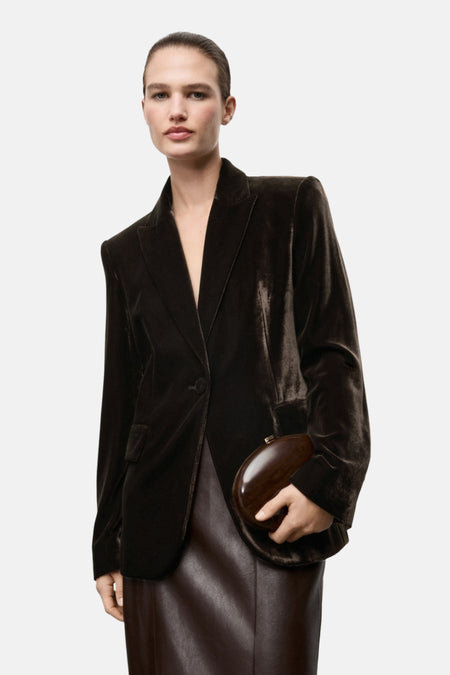 Bruine blazer van MANGO, gedragen met een bruine leren rok en een houten clutch.
