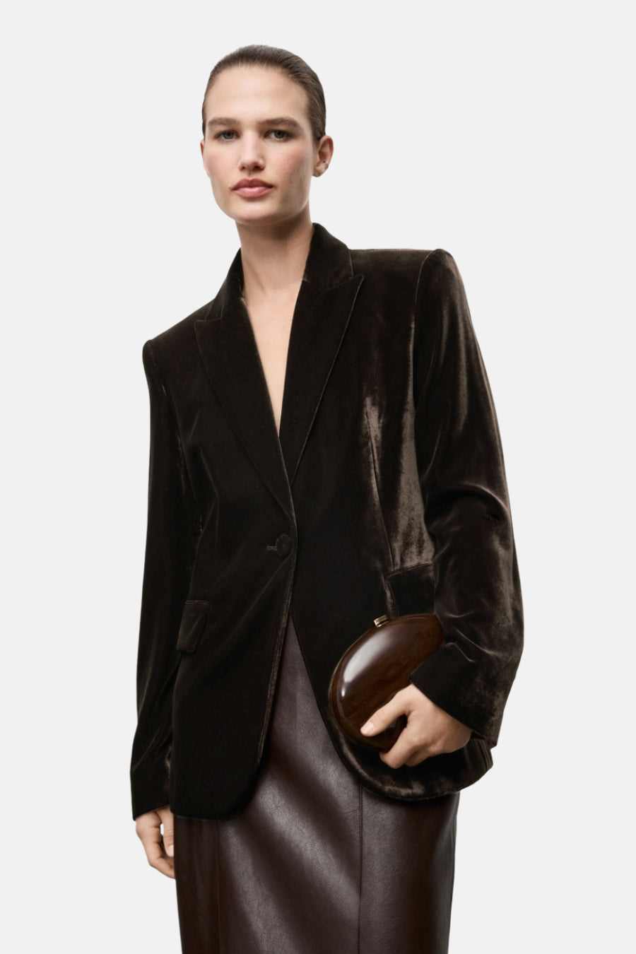 Bruine blazer van MANGO, gedragen met een bruine leren rok en een houten clutch.