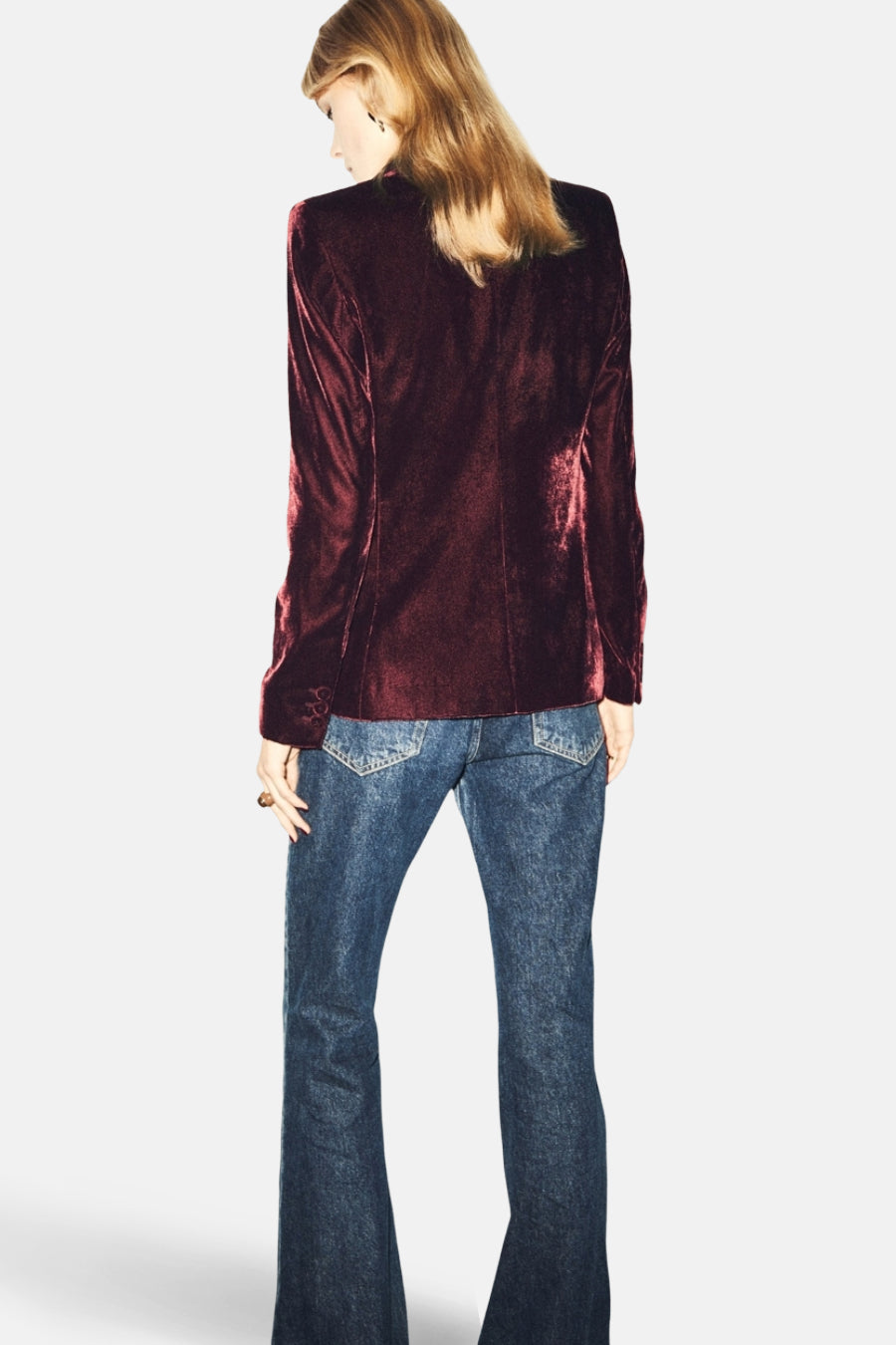 Blazer bordeaux en velours de MANGO, porté avec un jean évasé, vue de dos.
