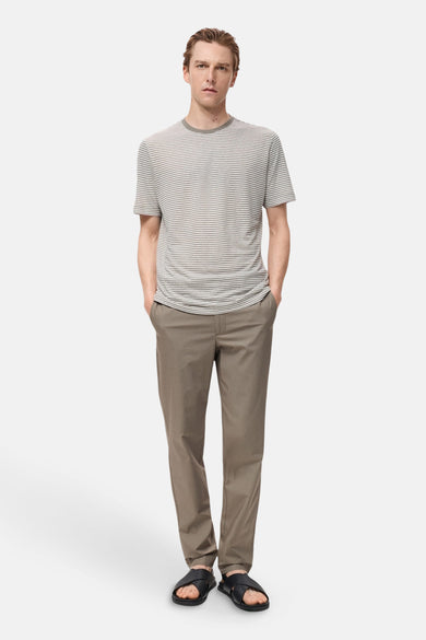 Pantalon d'automne brun de MANGO, porté avec un t-shirt rayé et des sandales en cuir.