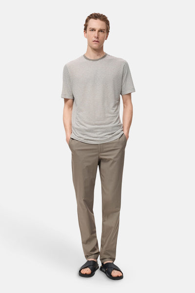 Pantalon d'automne brun de MANGO, porté avec un t-shirt rayé et des sandales en cuir.