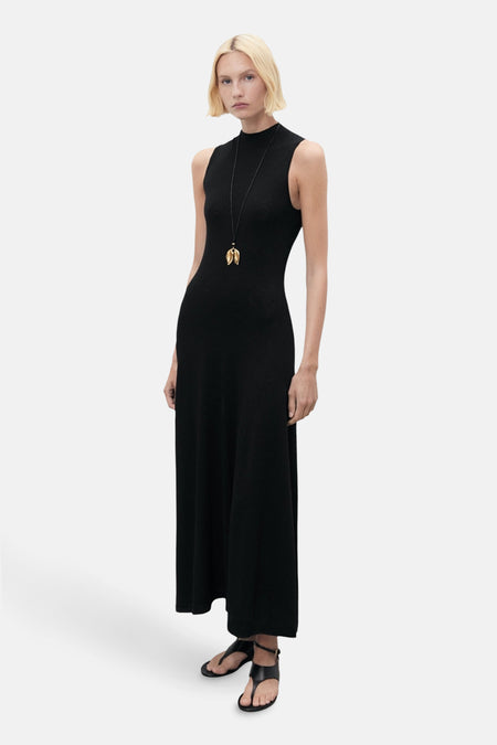 Zwarte lange jurk van MANGO, met een opstaande kraag en een gouden ketting.