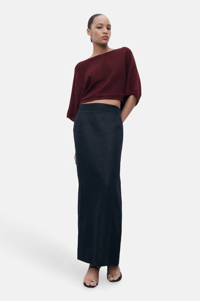 Bordeaux ronde hals trui van MANGO, gedragen met een zwarte lange rok en sandalen met bandjes.