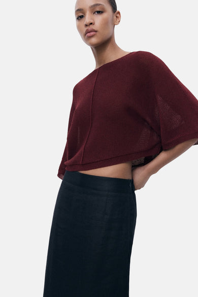 Bordeaux ronde hals trui van MANGO, kort en met korte mouwen, gedragen met een zwarte rok.