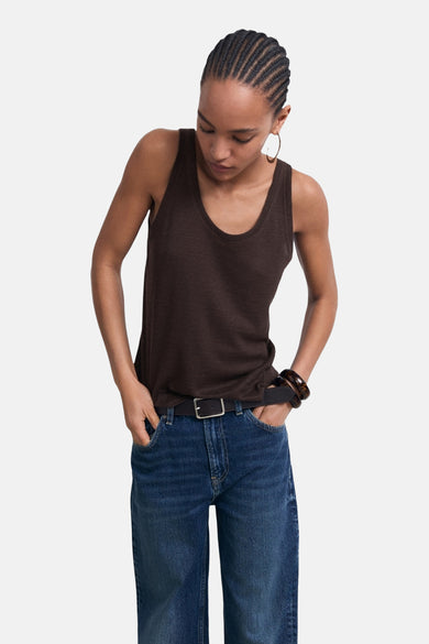 Bruin hemdje van MANGO, gedragen met een blauwe jeans en een zwarte riem, met Afrikaanse vlechten.