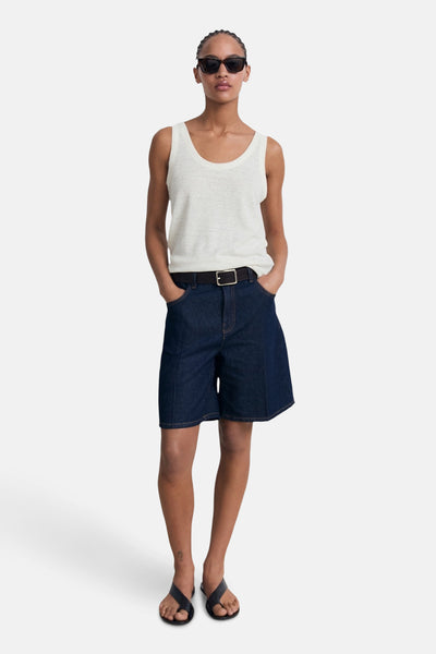 Débardeur beige de MANGO, porté avec un short en jean ample, ceinture noire et des sandales noires.
