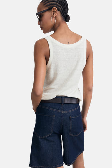 Beige tanktop van MANGO, gedragen met een donkerblauwe spijkerbroek en een bruine leren riem, achtergezicht.