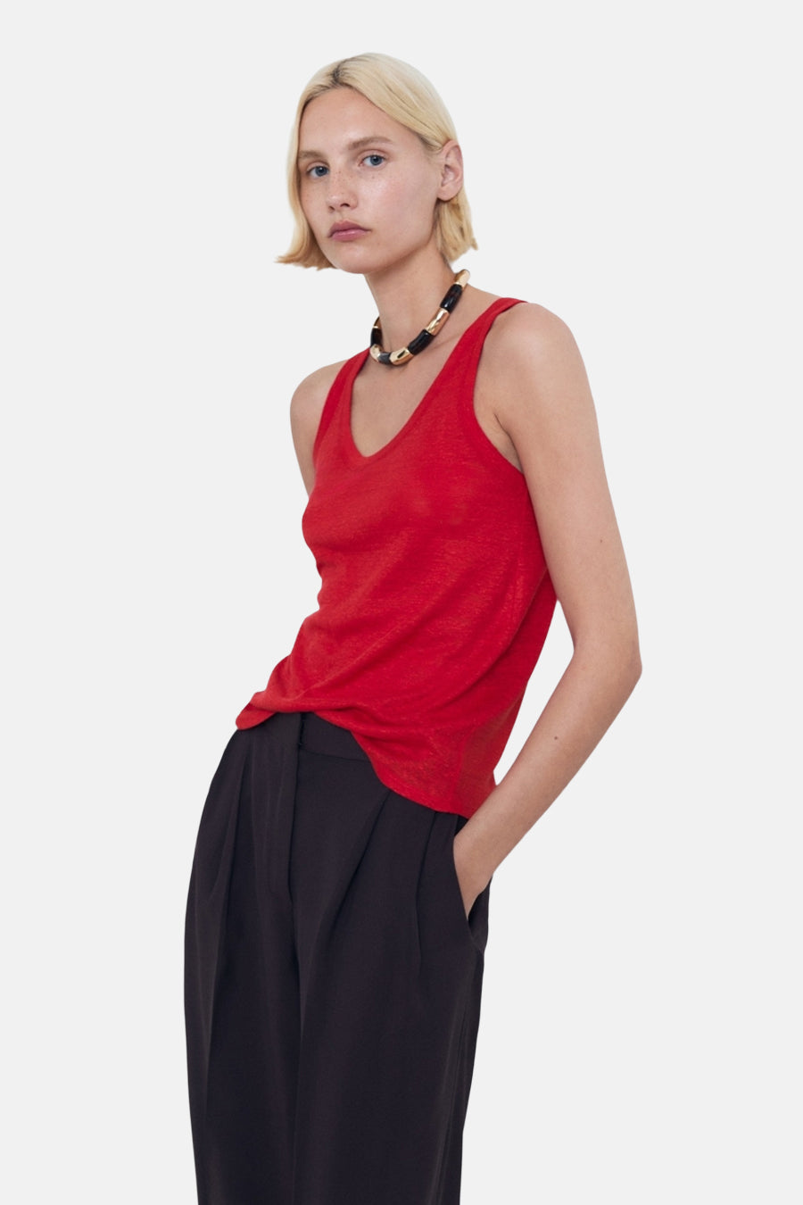 Rood hemdje van MANGO, gedragen met een zwarte broek met hoge taille en een textuurketting.