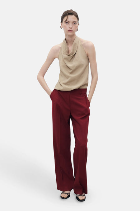 Rode schoudertas van MANGO, gedragen met een mouwloze beige top en een wijde rode broek.