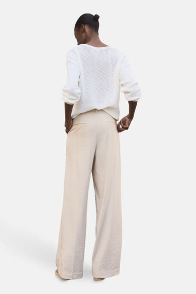 Beige wijde broek van MANGO, met een subtiele textuur en discrete achterzakken.