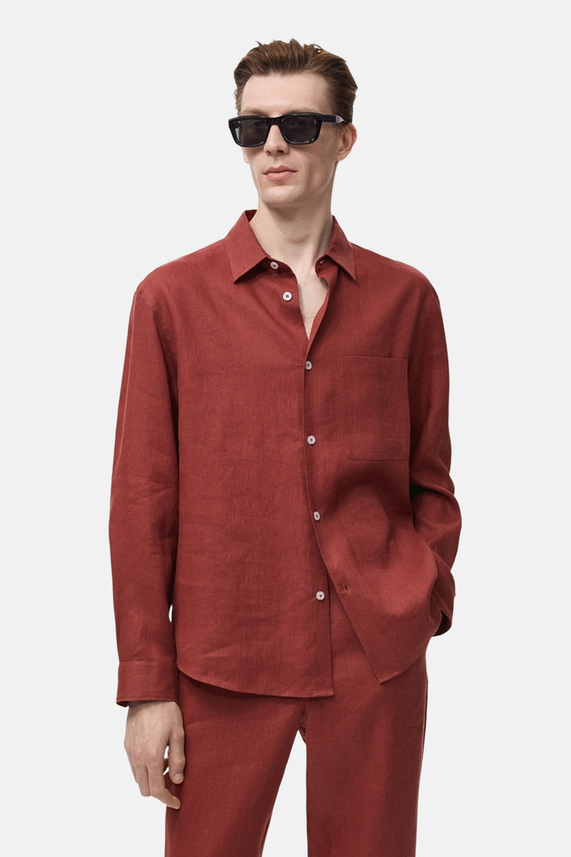 Chemise à manches longues rouge de MANGO, en lin, avec poche poitrine et boutons blancs.