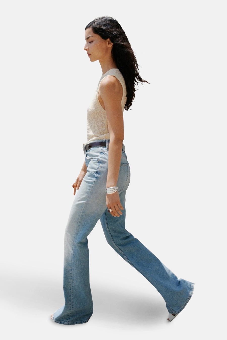 Jean évasé en denim bleu clair de MANGO, porté avec un top beige texturé et une ceinture marron.