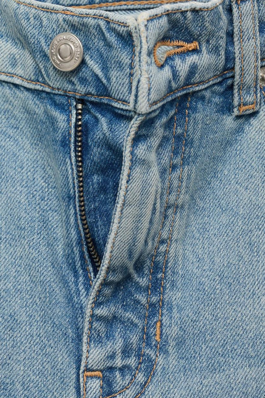 Jean évasé en denim bleu clair par MANGO, avec fermeture éclair apparente et détails de couture ocre.
