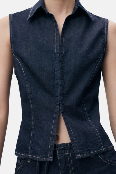 Mouwloos denim overhemd in donkerblauw van MANGO, met contrasterende stiksels en een opening aan de voorkant.