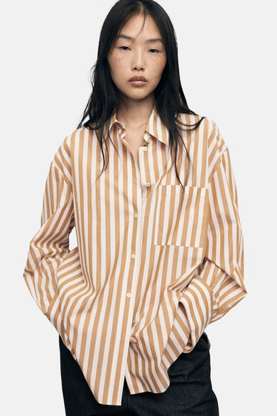 Gestreepte blouse met lange mouwen in meerdere kleuren van MANGO, van achteren gezien met een donkerblauwe broek.