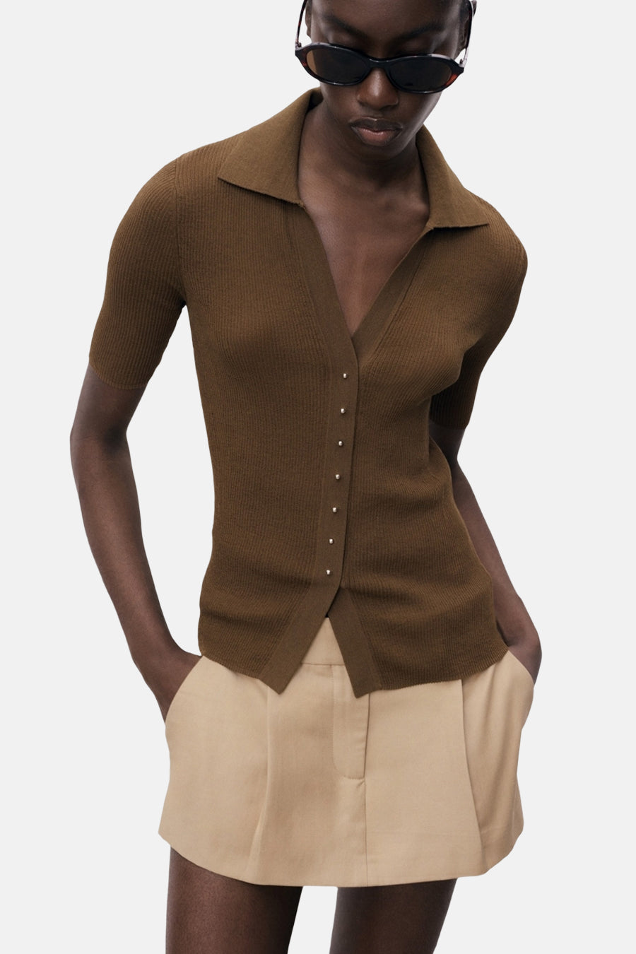 Korte mouwen poloshirt van MANGO, met knoopsluiting aan de voorkant, gedragen met een effen beige short.