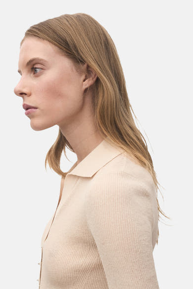 Beige poloshirt met korte mouwen van MANGO, in ribgebreide stof met klassieke kraag, zijaanzicht.