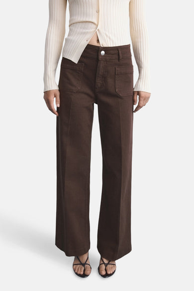 Gekleurde bruine jeans van MANGO, losse pasvorm met opgestikte zakken en gedragen met een geribbelde gebreide cardigan en zwarte sandalen.