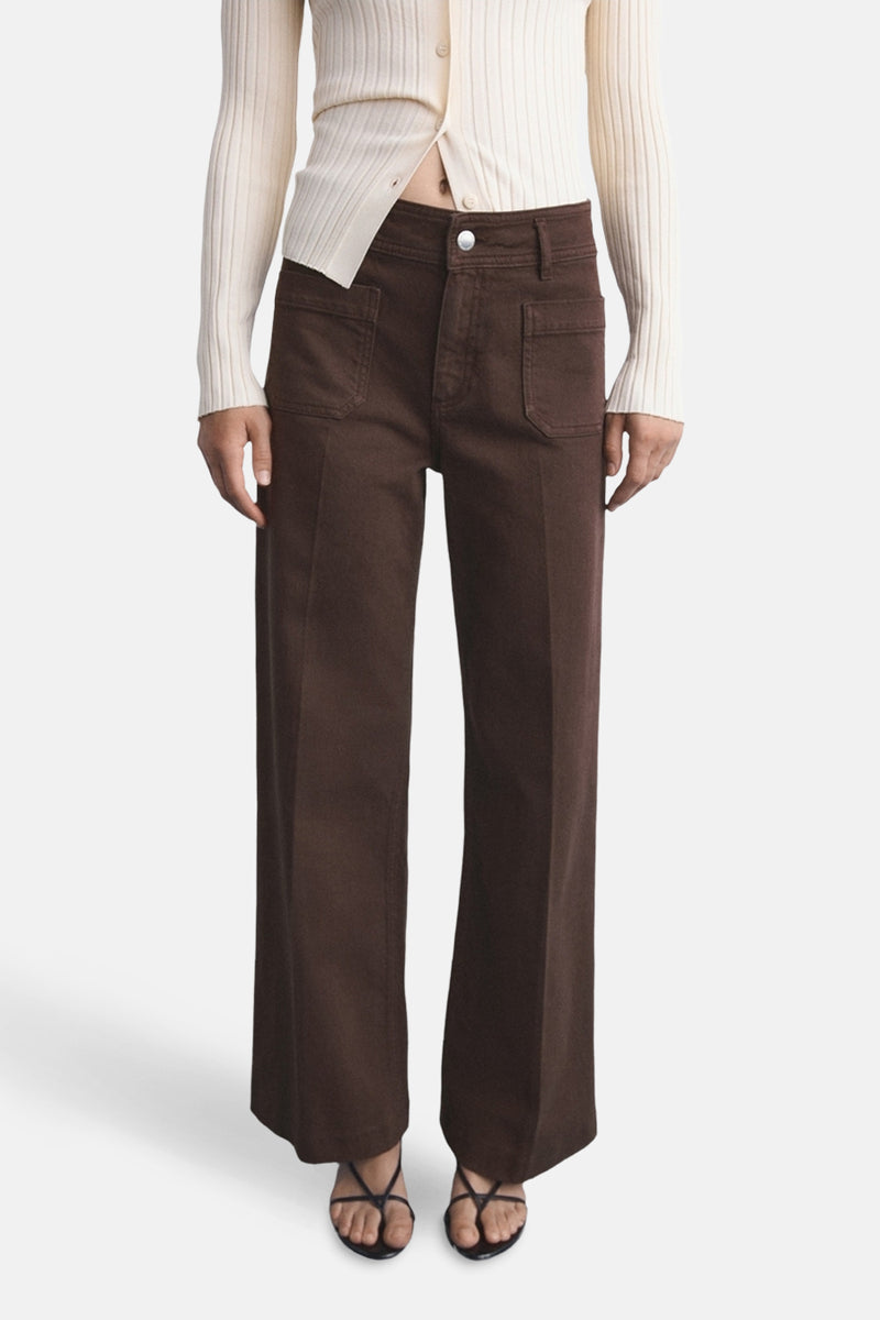 Gekleurde bruine jeans van MANGO, losse pasvorm met opgestikte zakken en gedragen met een geribbelde gebreide cardigan en zwarte sandalen.