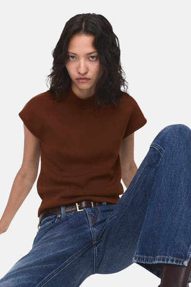 Top sans manches marron de MANGO, porté avec un jean bleu et une ceinture en cuir marron.
