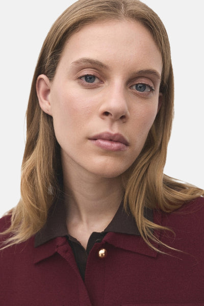 Bordeaux cardigan van MANGO, met bruine kraag en gouden knoop.