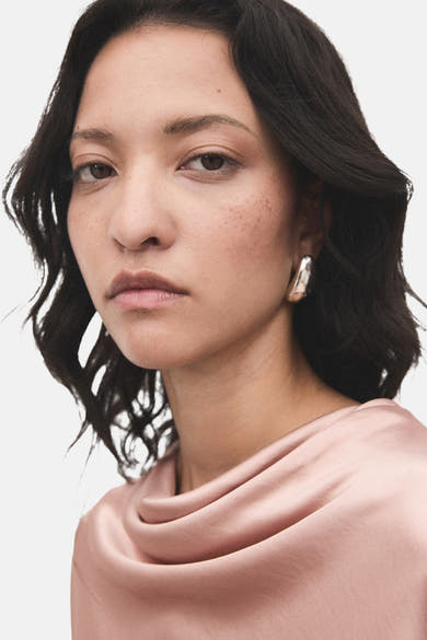 Roze blouse (lange mouwen) van MANGO, gedragen met zilveren oorbellen.