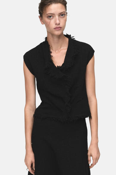 Zwarte korte rok van MANGO, getextureerd, gedragen met een bijpassend topje.