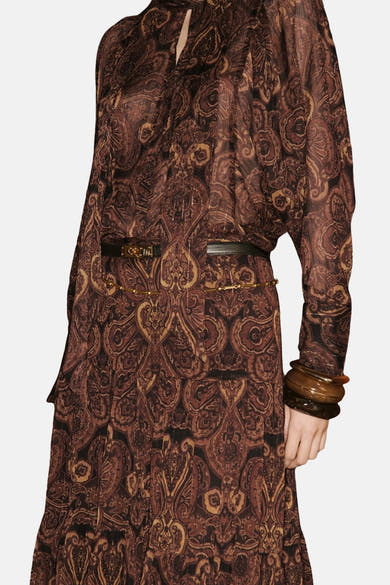 Bruine blouse met lange mouwen van MANGO, paisley-motief, zwarte riem en bruine manchetten.