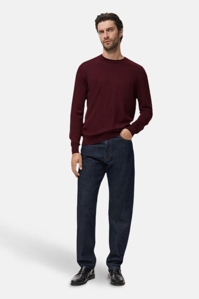 Bordeaux ronde hals trui van MANGO, gedragen met een donkere spijkerbroek en zwarte schoenen.