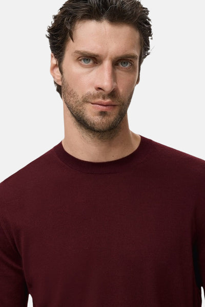 Bordeaux ronde hals trui van MANGO, gedragen door een man met een verzorgde baard.