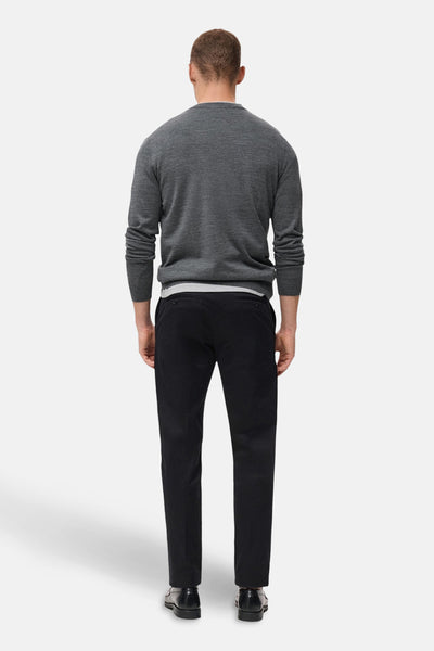 Grijze trui met ronde hals van MANGO, gedragen met een zwarte broek en nette schoenen, achtergezicht.