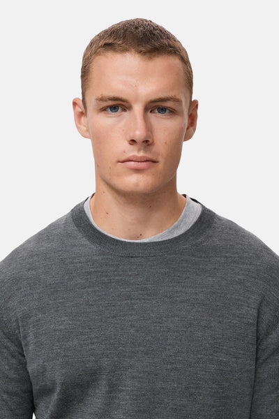 Grijze rondehals trui van MANGO, gedragen met een T-shirt met ronde hals.