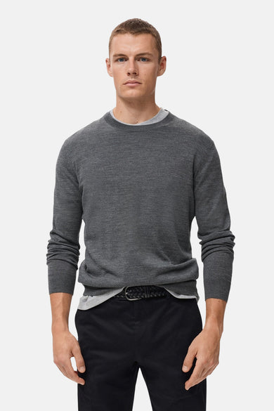 Grijze rondehals trui van MANGO, gedragen met een zwarte T-shirt en broek met een gevlochten riem.