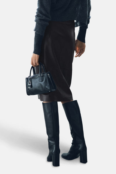 Jupe 3/4 marron de MANGO, portée avec un pull et des bottes noires.