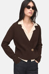 Gilet marron by MANGO, bouton doré, porté sur une chemise beige et un jean foncé.